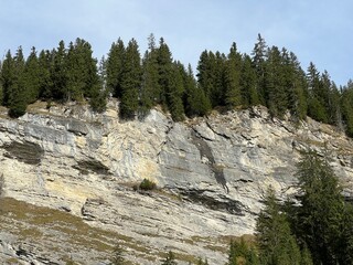 Steep stone cliffs and vertical rocks above the reservoir lake Panixersee (Lag da Pigniu) or...