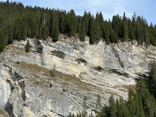 Steep stone cliffs and vertical rocks above the reservoir lake Panixersee (Lag da Pigniu) or...