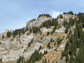 Steep stone cliffs and vertical rocks above the reservoir lake Panixersee (Lag da Pigniu) or...