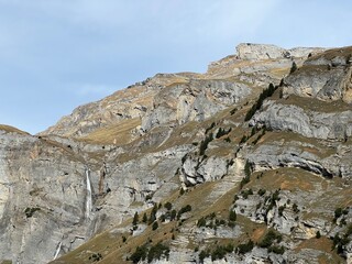 Steep stone cliffs and vertical rocks above the reservoir lake Panixersee (Lag da Pigniu) or...