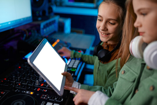 Young girls adjusting sound on sound mixer in radio station