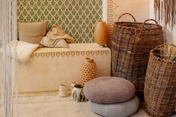 Middle east interior details in beige colors with boho decoration, cushions on couch near wall with ornate pattern