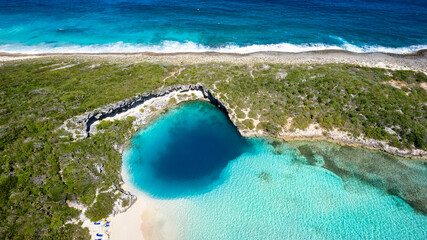 Aerial top view of the famous Dean's blue hole with the connecting turquoise lagoon next to the...