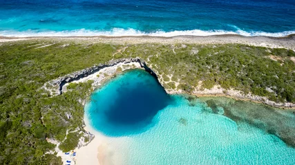 Foto op Plexiglas Aerial top view of the famous Dean's blue hole with the connecting turquoise lagoon next to the blue ocean, Long Island, Bahamas © moofushi