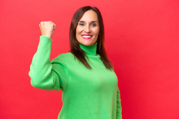 Middle-aged caucasian woman isolated on red background doing strong gesture