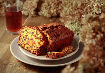  Fruit cake and tea on a wooden table with dried flowers.