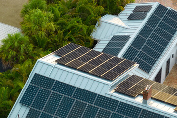 Aerial view of new american home roof with blue solar photovoltaic panels for producing clean...