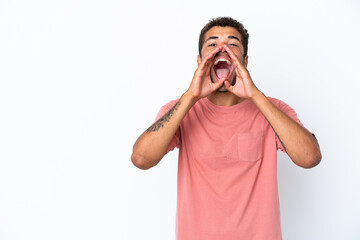 Young handsome Brazilian man isolated on white background shouting and announcing something