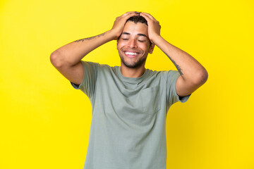 Fototapeta na wymiar Young handsome Brazilian man isolated on yellow background laughing