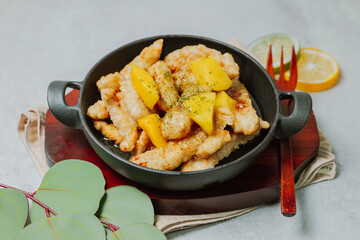 Chinese food sweet and sour pork dish in black bowl
