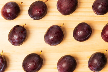 Fresh ripe plums lined with a pattern on the boards