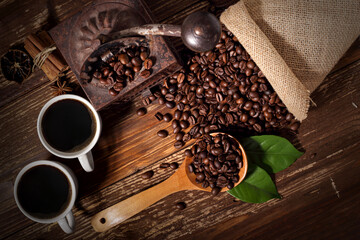 Obraz premium Macinino antico tazzine di caffe caldo e chicchi di caffè tostato con veduta dall'alto