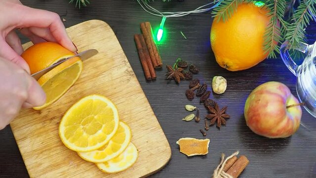 Making hot alcohol, cook mulled wine at home. add orange, apples and spices. traditional drink in winter, for christmas and new year holidays. stock pot, mixed with soup ladle. Closeup