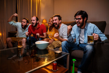 Group of five emotional adult friends watching sports match on tv, celebrating the victory of his team sitting on couch. Sports Concept. High quality photo