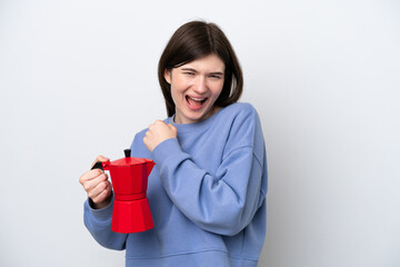Young Russian woman holding coffee pot isolated on white background celebrating a victory