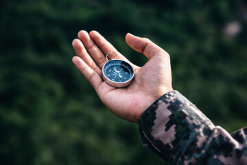 Soldiers holding compass for determines the location. Military Operation concept.