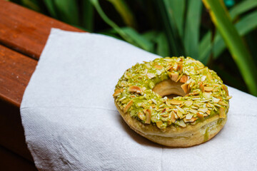 assorted colorful donuts, with assorted toppings of chocolate, nuts, almonds, cheese, strawberries, placed alone or stacked on top