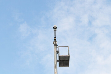 Fototapeta premium Closed-circuit CCTV, camera big size on pole in circle white blue sky background in sunlight. Tough cameras can record events such as traffic, accidents. prevent thief. Maintain safety important area