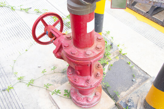 Valve fire hydrant large red light is installed beside outdoor light pole in bright sunlight. Standard construction safety and construction site. Safety equipment for people working in industrial.