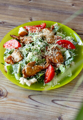 close-up view of delicious fresh caesar salad on plate on wooden table