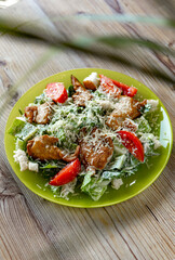 close-up view of delicious fresh caesar salad on plate on wooden table