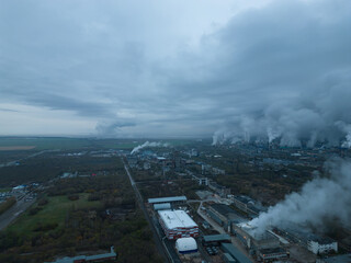Obraz premium Environmental pollution. Oil and gas industrial zone. Emissions from the chimneys of an industrial enterprise. Equipment for oil refining. Aerial photography. Bird's-eye view. Climate change.