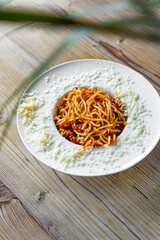 delicious spaghetti with tomato sauce on wooden table background, close up