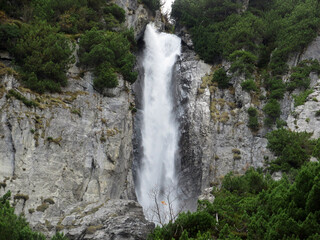 Obraz premium Schmuerfälle or Schmuer Waterfalls (Cascada da Pigniu oder Aua da Fluaz Wasserfälle) over the lake Panixersee (Lag da Pigniu), Pigniu-Panix - Canton of Grisons, Switzerland (Kanton Graubünden, Schweiz