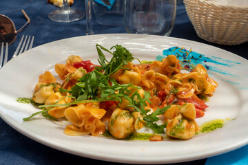 Italian pasta with fish and herbs on white plate