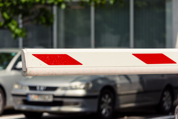 Red and white parking barrier to block access without payment in a public area in town - 543641682