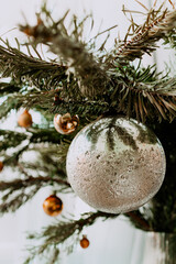 christmas silver ball on a Christmas tree branch. The concept of a village Christmas. Background postcard. bright day. Vertical image