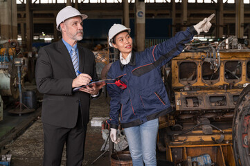 Caucasian engineer manager working with Asia engineer woman with spares at factory spares	