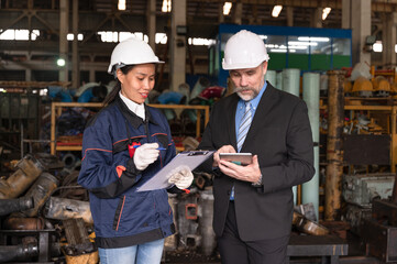 Caucasian engineer manager working with Asia engineer woman with spares at factory spares	