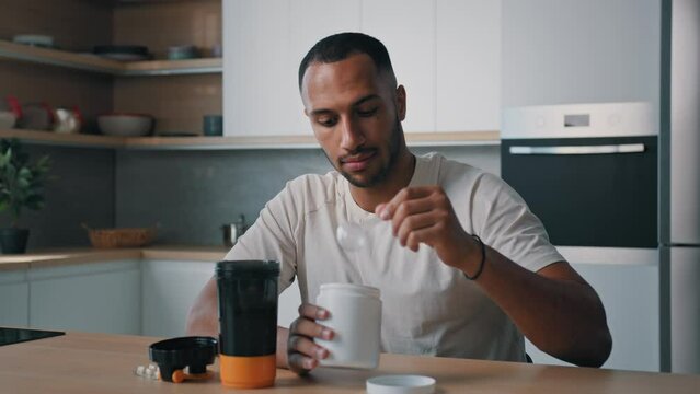 African American sports man bodybuilder athlete male guy prepare sport nutrition supplements soy protein cocktail in shaker plastic bottle powder healthy fitness diet for strong workouts weight gain