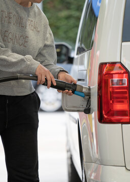 Woman fills natural gas into her car at a gas station
