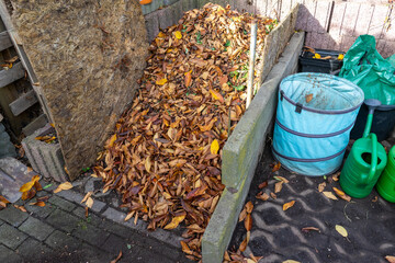 Kompost im Herbst voller Laub