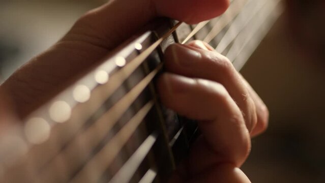 Acoustic guitar solo fingers on fretboard macro, guitar player playing music