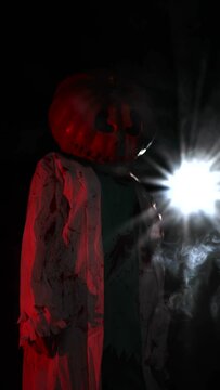 Woman has pumpkin on her head and portrays bloodthirsty zombie against smoke and dark background. Vertical video.