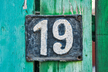 Old retro weathered cast iron plate with number 19 closeup