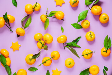 Tangerines with leaves on a lilac background.