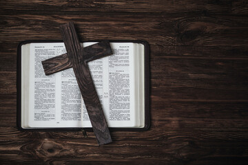 Holy bible on a wooden surface. Wooden cross on the bible. Free space for text. Christian picture....