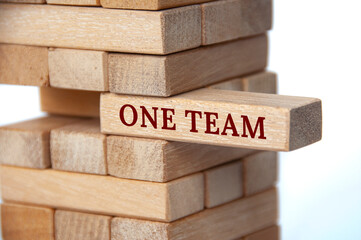 One Team text on wooden blocks. Working together as a team concept.