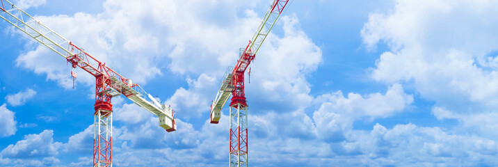 Tower crane in a construction site against a cloudy sky - construction industry concept with copy...