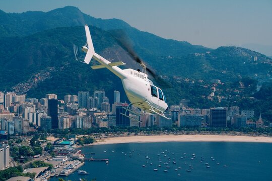 White Bell Jet Ranger helicopter taking off over Enseada de Botafogo, Rio de Janeiro City.