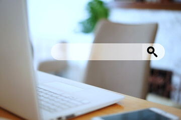 online search bar graphic with selective focus laptop computer on table home