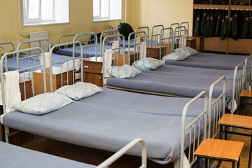 Soldier's beds in the barracks. A row of made beds in the Russian army, real life.