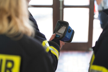 Firefighter looks at the screen of a thermal imaging camera in a training group