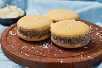 Traditional Argentinian alfajores with dulce de leche on wooden table. Argentine gastronomy concept.