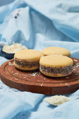 Traditional Argentinian alfajores with dulce de leche on wooden table. Argentine gastronomy concept.