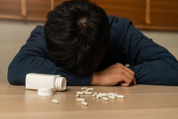 Close up drug bottle, pour several pills on table. stressed, asian young man, male take medicine,...